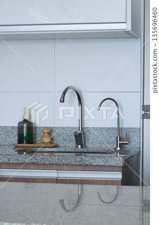 Modern kitchen countertop with chrome faucet and soap dispenser 135696460