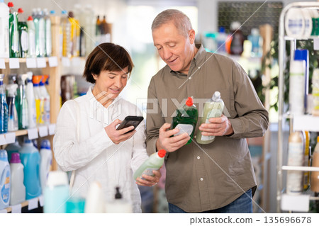 Couple man and woman scanning qr code for dishwashing detergent Couple man and woman scanning qr code for dishwashing detergent 135696678