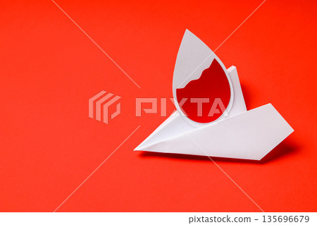 Paper drop shape with vibrant red color on a red surface Paper drop shape with vibrant red color on a red surface 135696679