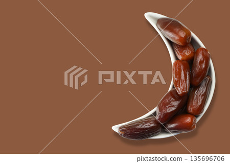 Dates placed in a crescent-shaped bowl for Ramadan festivity Dates placed in a crescent-shaped bowl for Ramadan festivity 135696706
