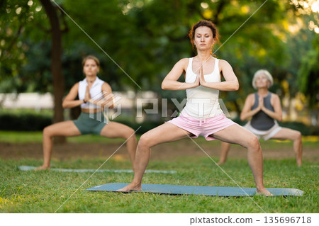 Adult woman doing yoga in park Adult woman doing yoga in park 135696718