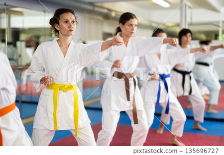 Group of womens practicing martial arts in gym. Active lifestyle and self defense concept 135696727