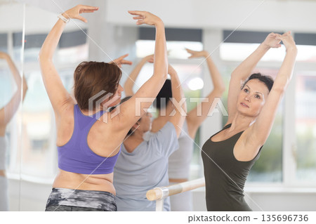Female ballet instructor conducting group classes for amateurs 135696736