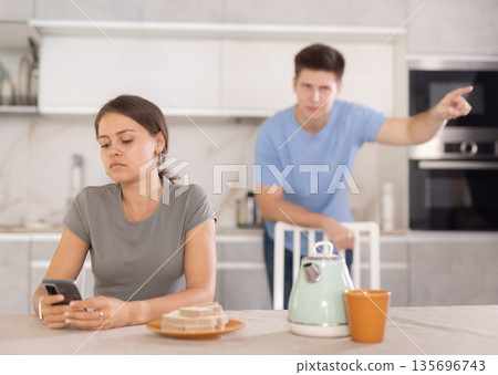 Young couple is quarreling while in kitchen, girl is silent Young couple is quarreling while in kitchen, girl is silent 135696743