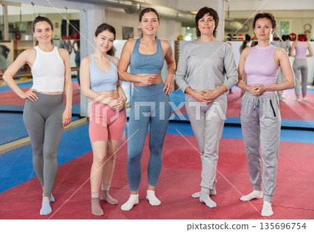 Women athlete pose before training in gym, female sport team Women athlete pose before training in gym, female sport team 135696754