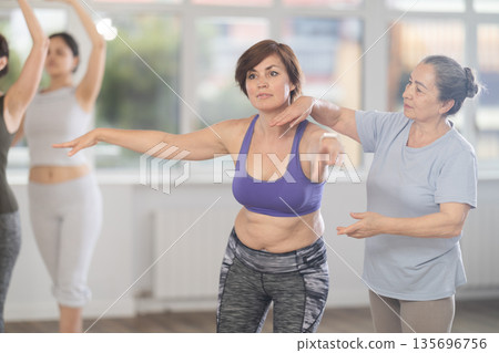 Elderly woman teacher correcting female dancers 135696756