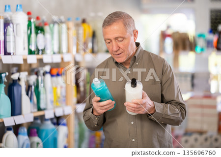 Elderly man choosing a shower gel and shampoo Elderly man choosing a shower gel and shampoo 135696760