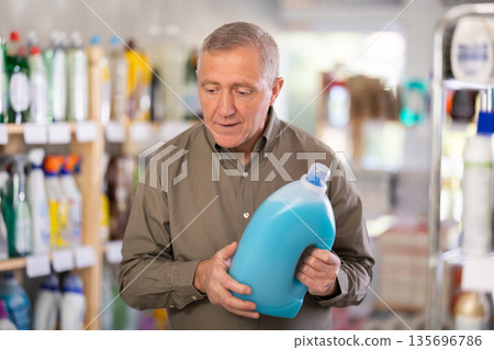 Male consumer with household chemical products for washing indoors 135696786