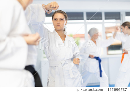 Two women trained to perform basic defensive karate installations and attacking combat techniques Two women trained to perform basic defensive karate installations and attacking combat techniques 135696787
