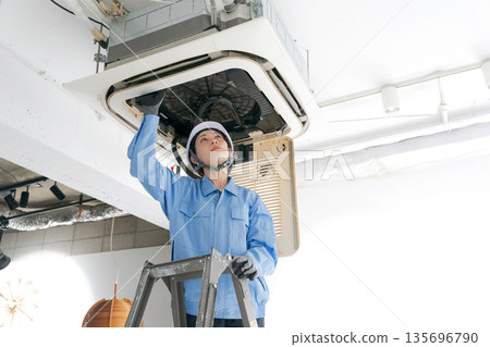 一名女工正在檢查空調 一名女工正在檢查空調 135696790