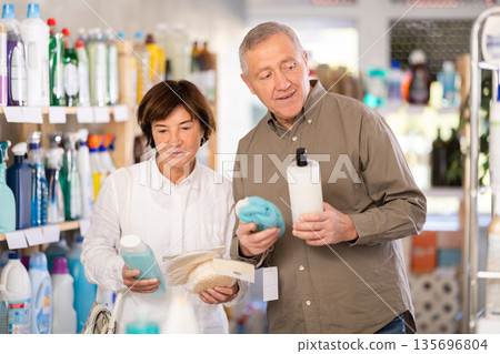 Couple man and woman choosing shampoo or shower gel and washcloth 135696804