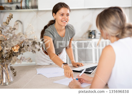 Young girl communicating with partner in the kitchen Young girl communicating with partner in the kitchen 135696838