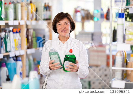 Elderly woman chooses dishwashing detergent in store Elderly woman chooses dishwashing detergent in store 135696841