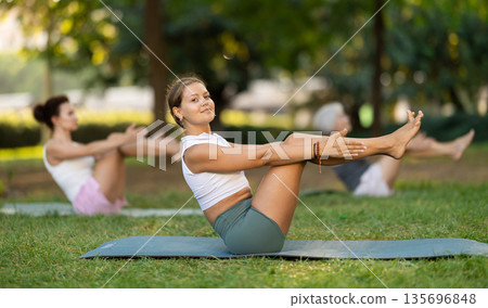 Young woman doing yoga in park Young woman doing yoga in park 135696848