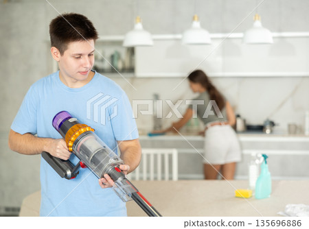 Positive guy and wife are cleaning kitchen Positive guy and wife are cleaning kitchen 135696886