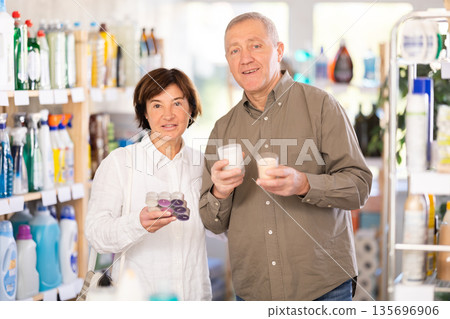 Couple man and woman choosing scented candles in store Couple man and woman choosing scented candles in store 135696906