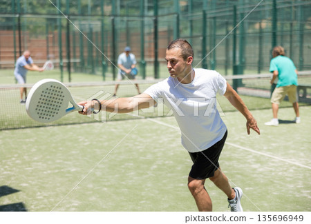 Male player serving ball during training padel in court Male player serving ball during training padel in court 135696949