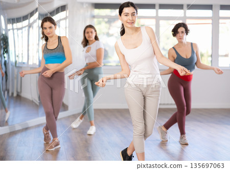 Young female teacher conducts modern hip hop dance lessons for group of girls Young female teacher conducts modern hip hop dance lessons for group of girls 135697063