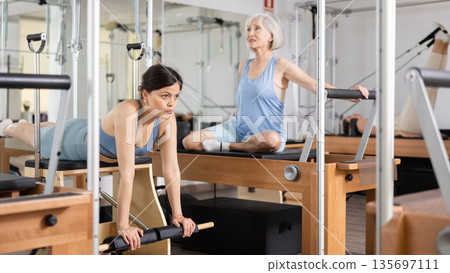 Young asian woman practicing pilates on wunda chair 135697111