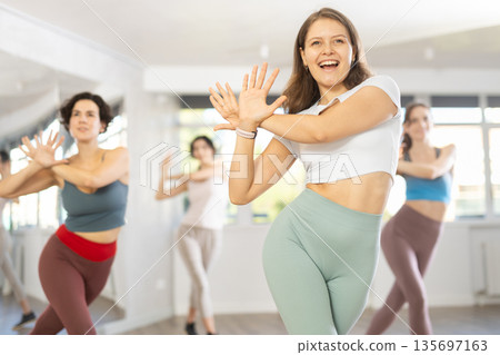 Young female teacher conducts modern dance lessons for group of girls Young female teacher conducts modern dance lessons for group of girls 135697163