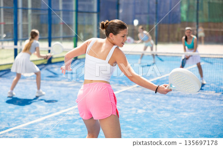 Young woman in sportswear playing paddle 135697178