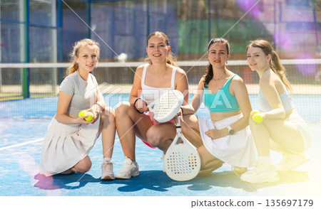 Team of female padel tennis players on court Team of female padel tennis players on court 135697179