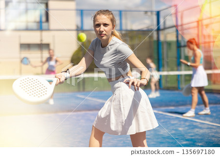 Athletic woman playing racket in paddle tennis weekend in parks 135697180