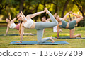 Group of young women doing stretching in park 135697209