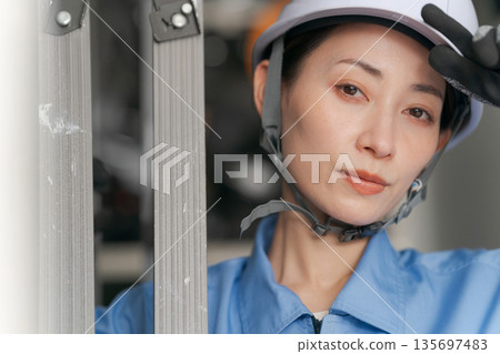 面帶微笑的女工扛著梯子 面帶微笑的女工扛著梯子 135697483