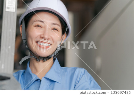 面帶微笑的女工扛著梯子 面帶微笑的女工扛著梯子 135697485