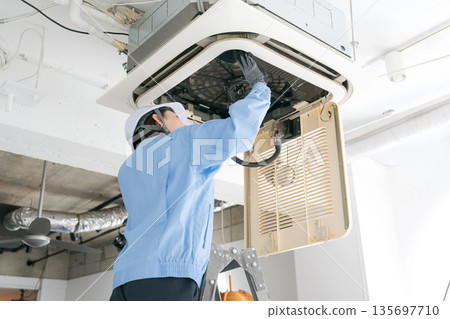 一名女工正在檢查空調 一名女工正在檢查空調 135697710