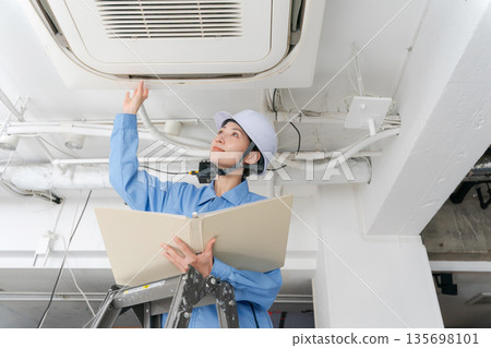 一名女工正在檢查空調 135698101