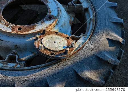 Old tractor wheel with morning rime frost 135698378