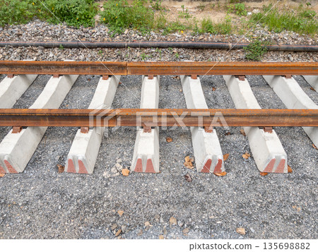 New railway tracks under construction on concrete sleepers. New railway tracks under construction on concrete sleepers. 135698882