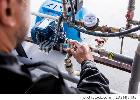 Technician checking water system nodes.Modern Industrial background Technician checking water system nodes.Modern Industrial background 135699432