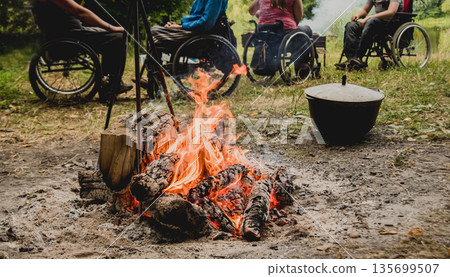 Group of disabled persons resting in a campsite with friends. Group of disabled persons resting in a campsite with friends. 135699507
