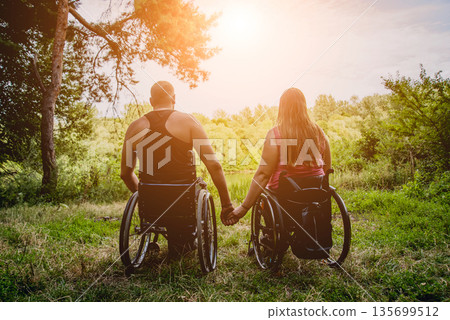 Handicapped couple resting in the forest near lake. Handicapped couple resting in the forest near lake. 135699512