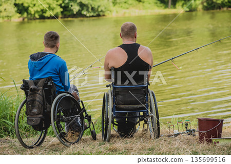 Handicapped men fishing at a lake. Wheelchair. Camping. Handicapped men fishing at a lake. Wheelchair. Camping. 135699516