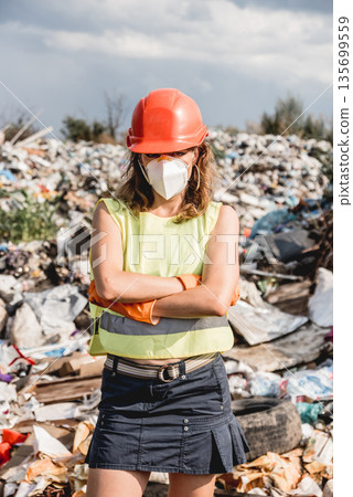 Woman volunteer helps clean the field of plastic garbage. Woman volunteer helps clean the field of plastic garbage. 135699559