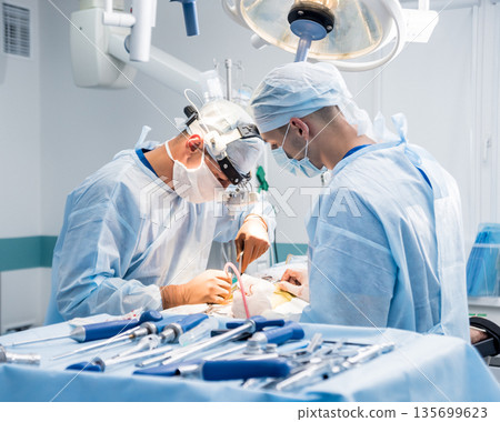 Spinal surgery. Group of surgeons in operating room with surgery equipment. Spinal surgery. Group of surgeons in operating room with surgery equipment. 135699623