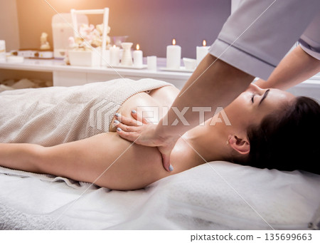 Beautiful young woman enjoying massage in spa salon. Cosmetology Beautiful young woman enjoying massage in spa salon. Cosmetology 135699663