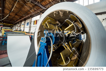 Rolled steel coils in storage areas of metalwork manufacturing. 135699773