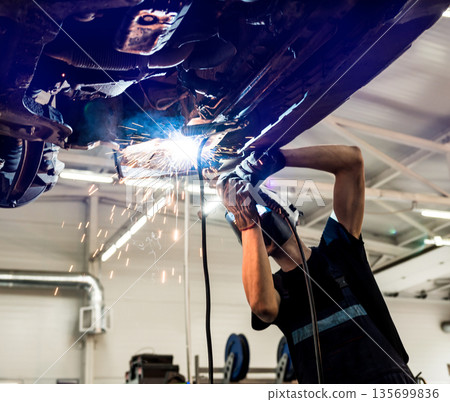 Car mechanic with protective mask welding car. Service station 135699836
