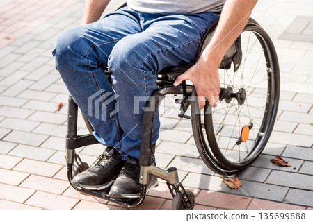 Handicapped man in wheelchair walk at the park alley Handicapped man in wheelchair walk at the park alley 135699888