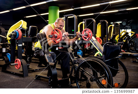 Disabled man training in the gym of rehabilitation center Disabled man training in the gym of rehabilitation center 135699987