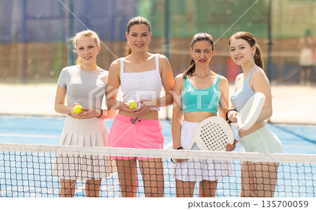 Team of female padel tennis players on court 135700059