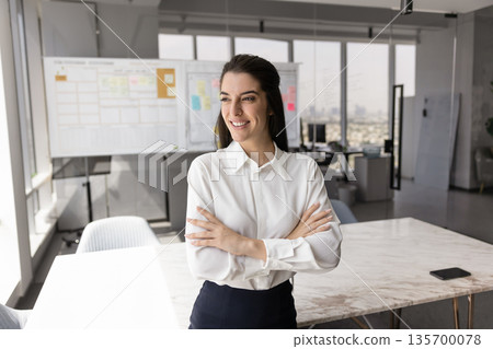 Latina businesswoman posing in modern conference room 135700078