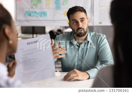 Young Hispanic man answers questions during job interview Young Hispanic man answers questions during job interview 135700161