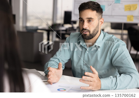 Professional man explains information presented in charts on table 135700162