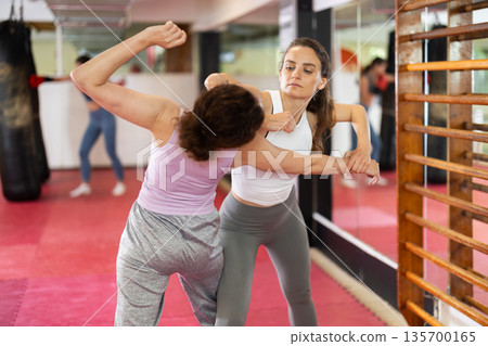 Two women practice self-defense techniques Two women practice self-defense techniques 135700165